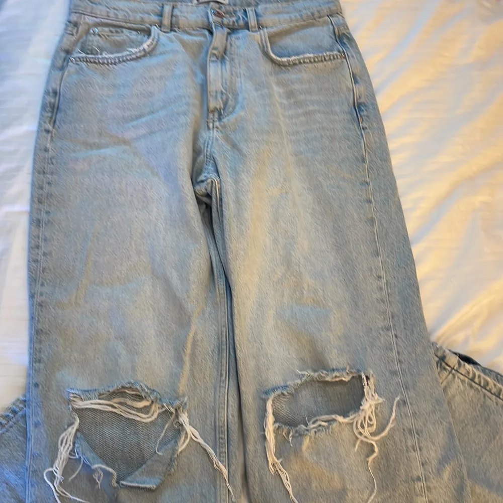 Nästan helt nya jeans med slitningar, byxorna är uppsprätta längst ner så de ska bli längre. . Jeans & Byxor.