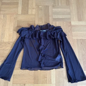 Meshtopp - Brun meshtopp med offshoulder modell och volanger. Vida armar. Aldrig använd (frakt tillkommer)