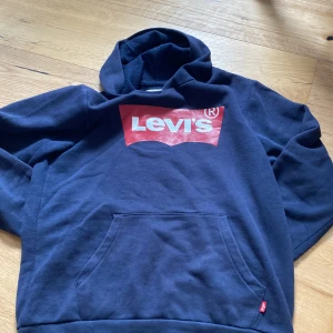 Mörkblå Levis hoddie - Tröjan är i storlek M och den är mörkblå och i gott skick den har används mycket men kommer inte till användning längre