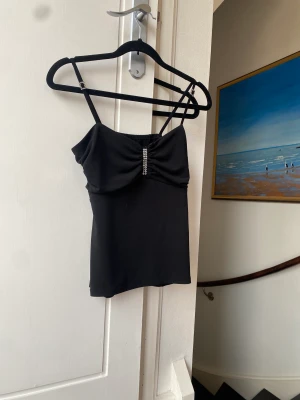 Topp - Topp med strass. Åkt av två pärlor vid bandet, men inget man tänker på. Står ej storlek eller märke men är som en S. 