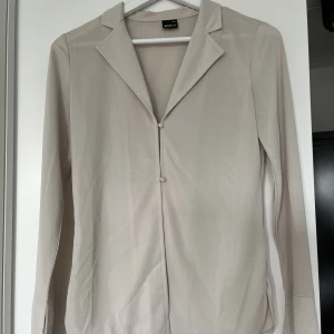 Blus från Gina tricot - Blus i fint material med två knappar. Slits på ärmarna och sidorna. St xxs men passar även xs och xs/s