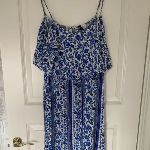 Säljer klänningen åt min mamma då hon inte använder den längre. Jätte fint mönster i fina blåa färger. Lite längre klänning med dubbelt tyg vid brösten för en finare detalj.
