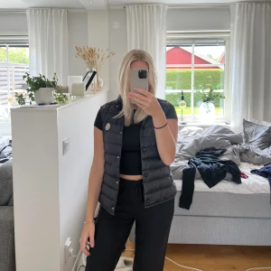 Moncler väst - Säljer nu min älskade Moncler väst då den inte kommer till användning längre. Den är i storlek 2 (passar dig som är en XS-S) och är sparsamt använd! Äkthetskod och kvotto finns och den kommer med orginalkartongen! 🖤