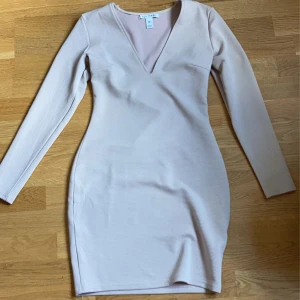 Beige långarmad klänning - Jag säljer min klänning som jag aldrig använt men köpt på en loppis i bra skick, den satt jätte fint på mig den framhävande mina kurvor lite mer de ända problemet är egentligen är att man såg lite va min bh, tror den skulle sitta bättre på längre människo