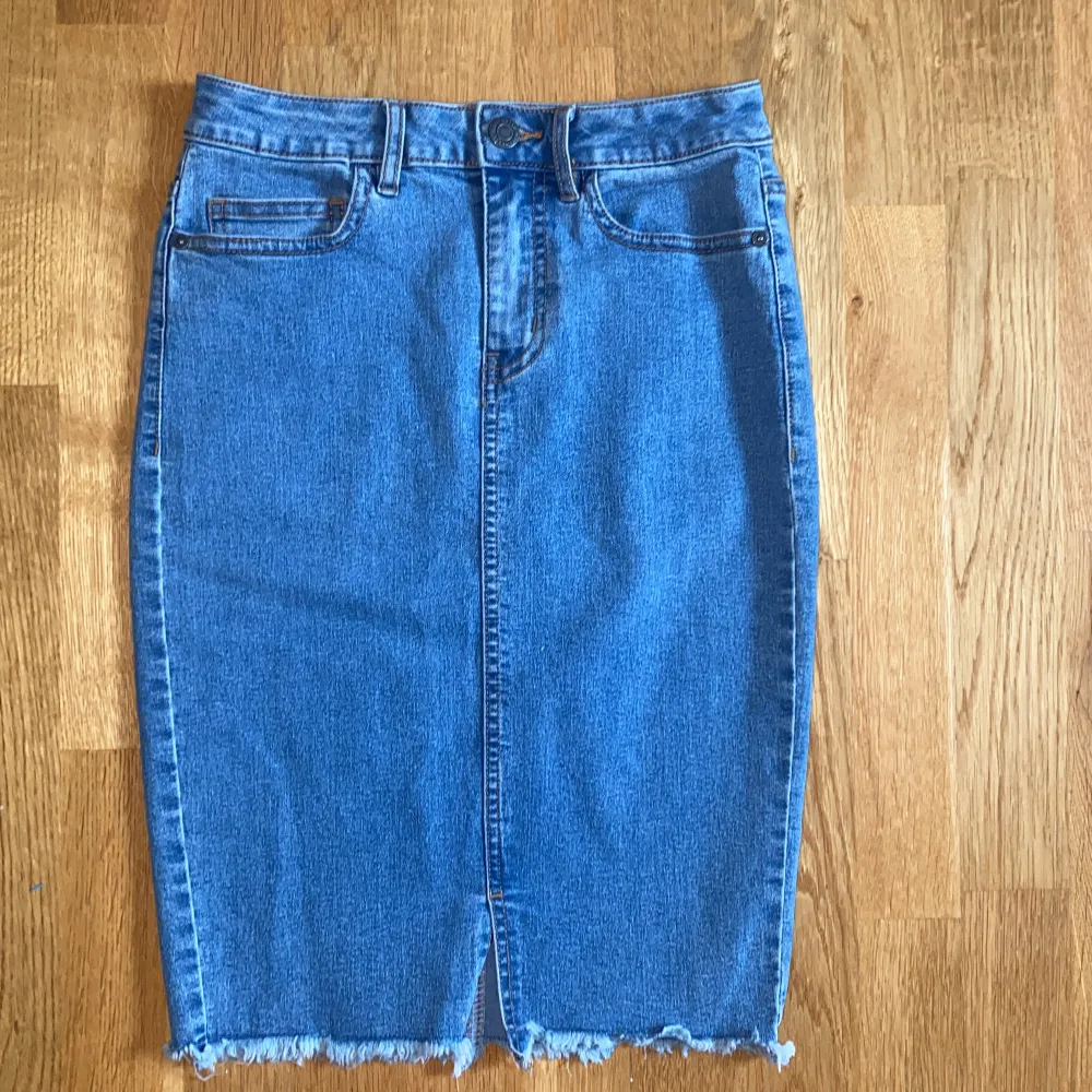 Blå jeanskjol köpt i Vero Moda. Jeanskjolen är knälång och i storlek XS. Använd ett fåtal gånger.. Kjolar.