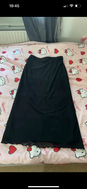 Svart lång kjol  - Svart lång kjol har lace över tyget. 