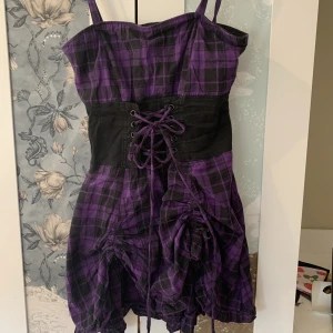 Alt klänning - Lila kläning med korsett och ”volanger”. Har både dragkedja och är stretchig k ryggen