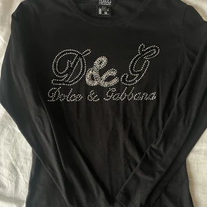 Dolce & Gabbana tröja med paljetter - Svart dolce & Gabbana långärmad tajt tröja med olika sorters paljetter. Köpt second hand och saknas lite paljetter se bilderna. Skulle inte säga att det är något som märks av särskilt tydligt.