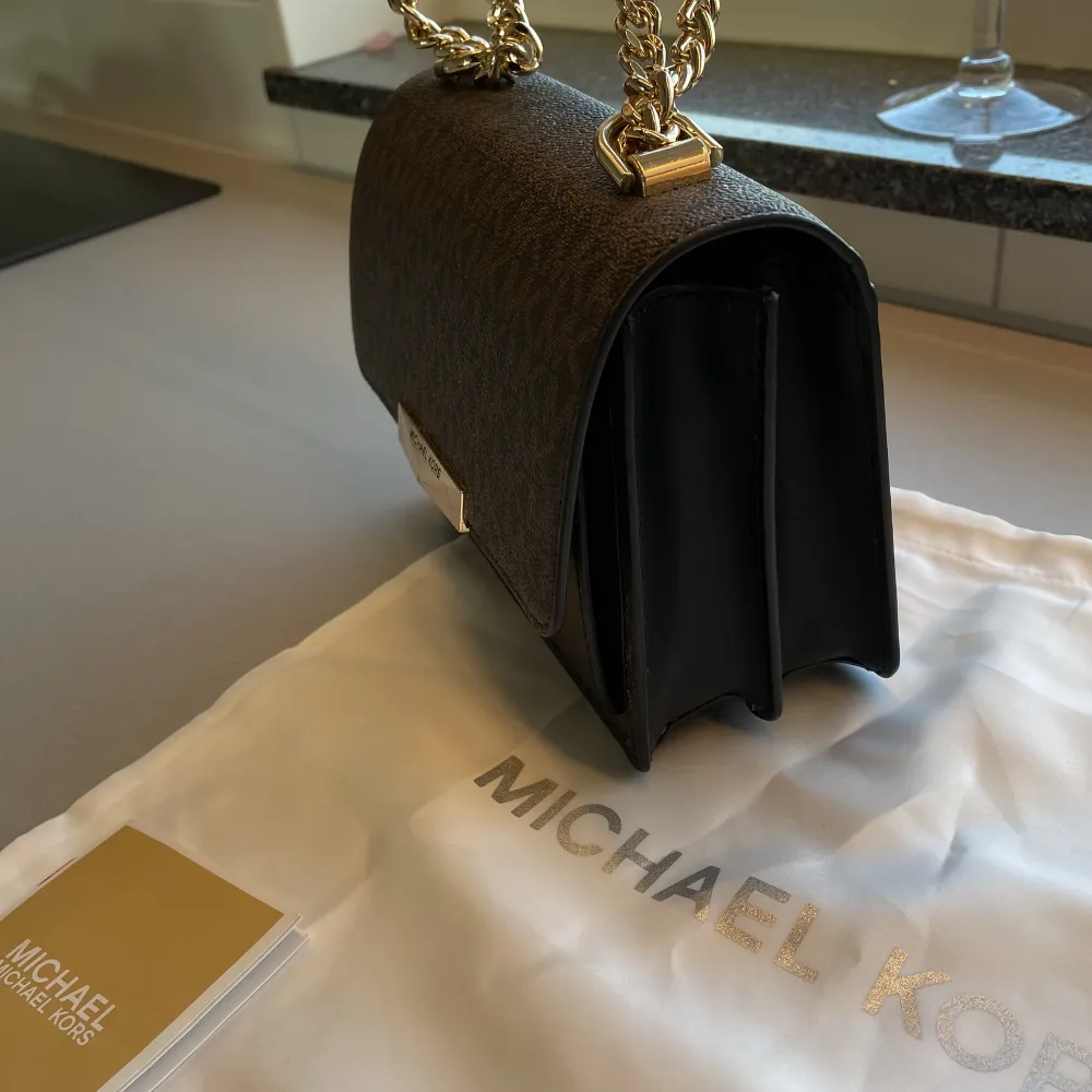 Michael Kors väska med guld detaljer som går att ha både kort på axeln och lång. Köptes i Maj 2022 för 2399kr. Väskor.