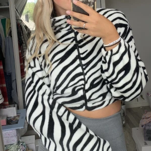 Zip-tröja  - En zip-tröja med zebramönster i en kortare modell, suuuupermjukt material. Köpt på zara (tror jag) 