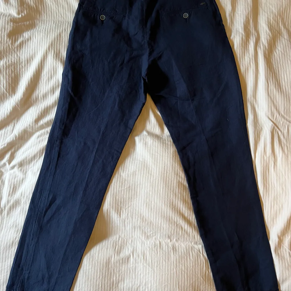 Byxor i linne/bomull-blandning marinblått, nyskick. Strl 40 motsvarande 29/30 i jeans. Sytt slag nedtill.. Jeans & Byxor.
