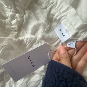 Vila topp/blus - Jättesöt vit sommartopp ifrån vila! Aldrig använd (lappen sitter kvar)💕 storlek 38/M men sitter mer som en S/XS. Superfin men kommer ej till någon användning! Lite skrynklig på mina bilder men det är endast då den legat i garderoben länge! 🌸