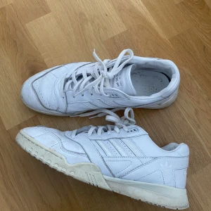 Adidas vita sneakers - Säljer ett par vita adidas sneakers i strl 46. Använda men i bra skick. 