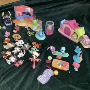 Littlest petshop värld - - 21 djur inklusive 1 fisk i akvarium - Petshop café med tillhörande inredning.  - Lekplats med bl.a. sandlåda, gungbräda, cykel.  - Petshop hus - En väska för ett djur.  - Accessoarer som keps, tiara och glasögon.