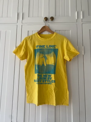 Harry Styles Fine Line T-shirt  - Harry Styles Fine Line T-shirt i gul och blå. Använd få gånger, bra kvalitet!