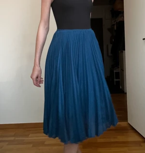 Blå plisserad midikjol - Blå / petrol plisserad midikjol från samsoe samsoe. Har vissa spår av användning bland annat lite slitage vid blixtlåset, inget som märks så mycket dock. 
