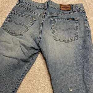 Vintage lågmidjade gul och blå jeans  - Äkta vintage jeans som är över 20 år gammal och därav väldigt svåra att få tag på! De är i så fint skick och verkligen helt perfekta! Lågmidjade och bootcut i den perfekta färgen! 💗💗💗 Midjemått (rakt över) : 39. Innerbenslängden : 83 cm 💋