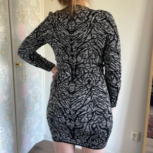 Mönstrad klänning stretch strl 38 - Super tjusig och smickrande mini klänning med en osynlig dragkedja på ena låret för att skapa en slits. Tyget är rätt tjockt och tungt-känns väldigt lyxigt! Svart & grå-silvrig. Massa stretch och sitter som en smäck! 