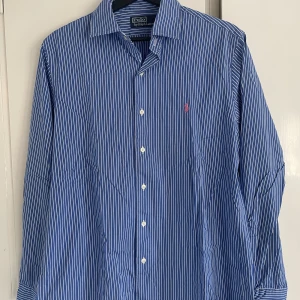 Ralph Lauren skjorta - Vit ljusblå randig skjorta. Storlek M. Felfritt skick, det ända är att den inte är strykt. Titta in profilen för fler skjortor och klädesplagg