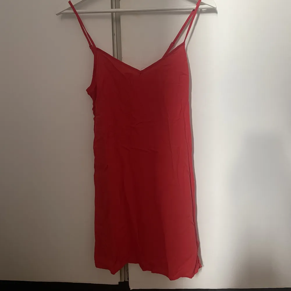 Röd klänning med hålbroderier från H&M, saknar en knapp där bak men inget som påverkar hur den sitter! Köparen står för frakt. Klänningar.