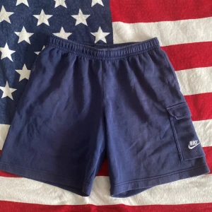 Nike cargo pocket fleece shorts - Hej säljer dessa fina shorts från Nike Shortsen är lite solblekta men färgen är fortfarande en tydlig blå. Finns en cargo ficka på vänster ben. Storlek L Vid frågor eller intresse skriv.
