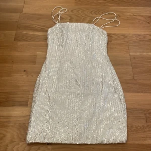 Paljettklänning  - Silvrig paljettklänning i nytt skick! Storlek 34 men är rätt så stretchig.