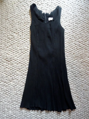 Svart klänning - I fint men något använt skick! Härligt ”skrynkligt tyg” och fin passform, figurkramande! Köparen står för frakt 