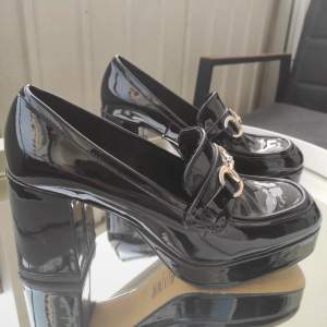Laddar upp igen pga oseriösa köpare. Svarta skor med bred klack från H&M. Har även guldiga detaljer. Storlek 38.