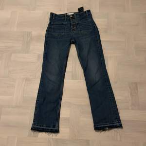 Mörkblåa jeans med två fickor framtill och uppsprättade nedtill då det ingår i modellen de är modellists och är nästan helt o anvönda