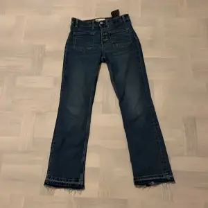 Mörkblåa jeans med två fickor framtill och uppsprättade nedtill då det ingår i modellen de är modellists och är nästan helt o anvönda