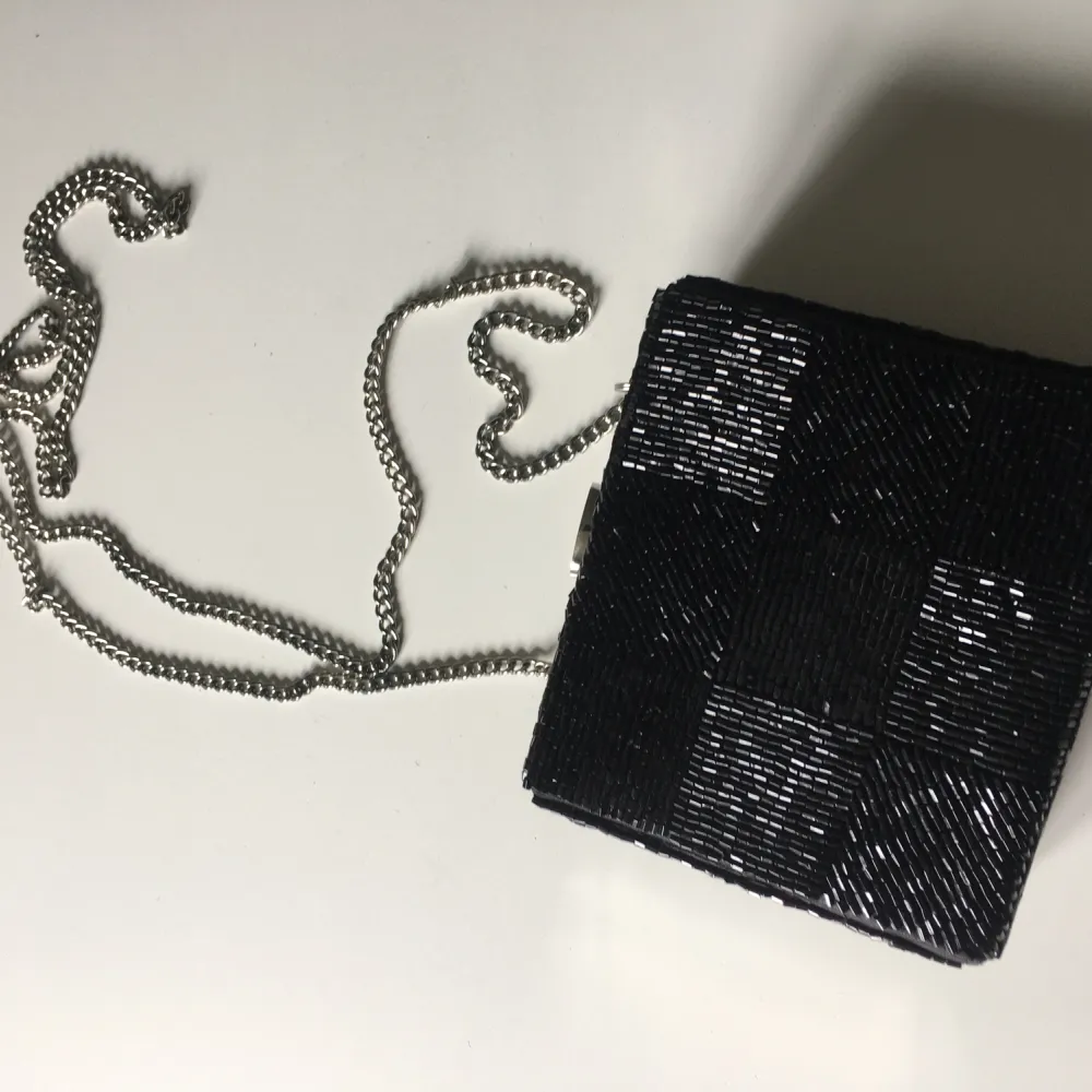 Liten svart väska med pärlor. Kan användas med eller utan axelrem.  Nyskick. . Väskor.