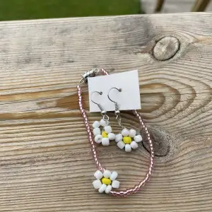 Handgjorda örhängen och armband, rosa med blommor. Säljer då de aldrig har använts, armbandet är gjort med resårband och passar därmed de flesta!🫶