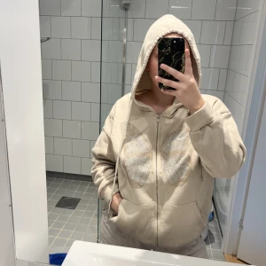 Oversized ziphoodie - Skiftet Hoodie med strass tryck. Tvättad många gånger och alla diamanter är kvar. Väl använd men inga anmärkningar. Katt finns i hemmet <3 