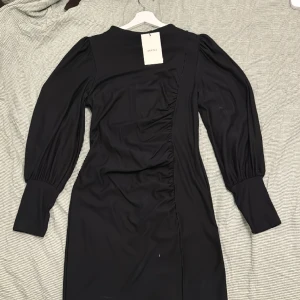 Gestuz klänning  - Svart snygg klänning från Gestuz. Oanvänd med taggen kvar. Faller snyggt på med sina detaljer, se sista bilden. Nypris 1099kr