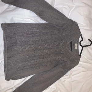 Stickad tröja - Säljer denna jättefina tröja då den ej används. Tröjan är brun med flätat  mönster på framsidan. Den passar superbra på mig som bär storlek s. Inga defekter förekommer. 