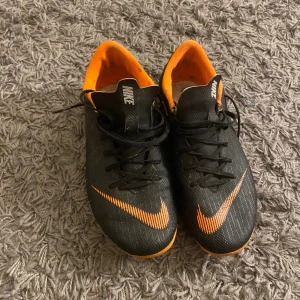 Nike fotbollsskor  - Svart/oganga fotbollskor, väl använda men ej några skador storlek 37,5