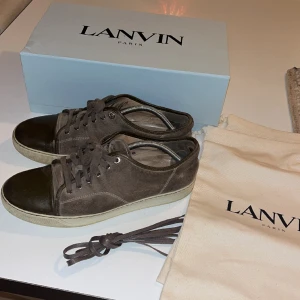 Lanvin cap toe - Lanvin cap toe sneaker Storlek 44  Bruna med mocka  Följer med box, dustbag och nya skosnören Använda men i mycket fint skick    Lägg bud!!! 
