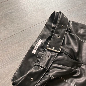 Skinnbyxa från NA-KD  - Skinnbyxor med bälte som är i nyskick. 