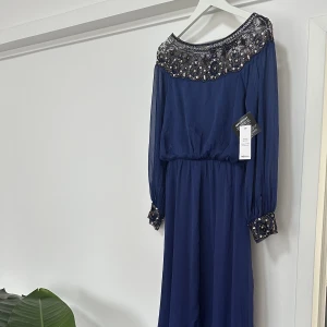 Balklänning/ maxiklänning - Embellished off shoulder Dress från Nly Eve. Underbar klänning, helt ny och oanvänd med prislapparna kvar. Även slutsåld och går inte längre att få tag i. Nypris 800kr.