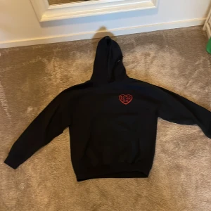 Svart Hoodie med coolt tryck - Skön svart hoodie men riktigt snyggt tryck. Är L men sitter som M. 
