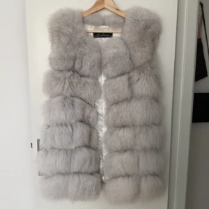 Maclauren äkta pälsväst  - Väst i äkta räv. Satinfoder. Knäppning med hyska och ögla. Köpt på MonroeWold. Nyskick. Passar storlek 34-38. 