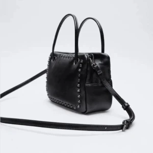 Zara väska - Säljer denna väska med nitar från zara! Otroligt snygg men använder andra väskor mer drf jag bara använt den fåtal ggr! Som ny men säljs ej kvar i butik .