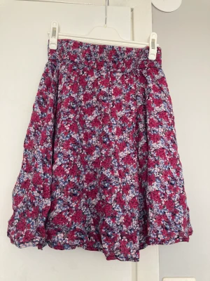 Kjol - En jättefin blommig med knappar fram kjol aldrig använd 