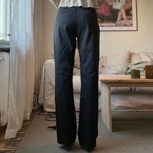 Lågmidjade kostymbyxor - Sjukt snygga lågmidjade kostymbyxor från Kappahl i storlek 38. De är svarta med subtila ränder. Midjemått 74 cm och innerbenslängd 77cm. Något långa på mig som är 162cm. Sitter oversized på mig som brukar ha S vilket skapar en lågmidjad look. 