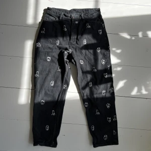 Svarta momjeans med ansikten - Så coola svarta momjeans från monki! På mig som är 160 går dem precis till mina vrister. Det står att det är w29 men jag brukar ha w27 och på mig passar dem bra. Säg till om jag ska skicka mått!🖤