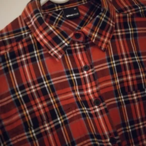 Röd rutig skjorta för kvinnor. Gina Tricot. Strlk: 34 / XS-SMALL. Bomull. Oanvänd och felfri. - Röd rutig skjorta för kvinnor. Från Gina Tricot. Strlk: 34 / XS-SMALL. Bomull. Oanvänd och felfri.