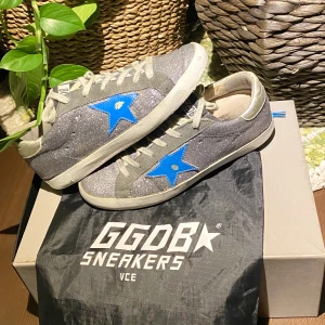 Golden Goose Superstar Blue Glitter Sneakers - Hej, säljer ett par Golden Goose glitter sneakers med blå stjärna. Skorna är i väldigt bra skick. Såldes i sämre skick på eBay för runt 4600kr. Storlek 38 och True To Size. Dustbag medkommer vid köp. Priset är inte hugget i sten. Hör av dig vid intresse.