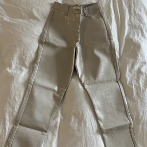 Ormskinn byxor - Glansiga ormskinnsbyxor i beige köpta på ASOS. Knappt använda och är i storlek 36