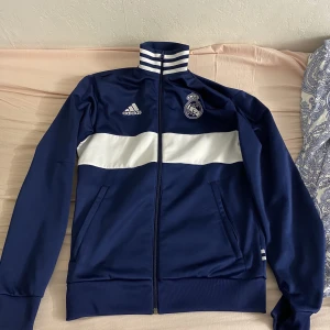 Real Madrid kofta - Säljer en real Madrid kofta som knappt är använd och jätte bra kvalitet. Den är köp på unisport och säljs väldigt billigt. Det är storlek S på koftan. 