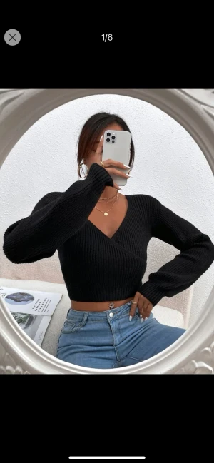 Svart stickad  - En relativt kort stickad tröja med urringning, bra skick, aldrig använd 